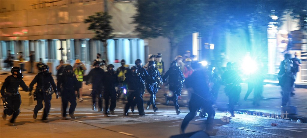 反對逃犯條例修正草案二讀的上萬名香港示威民眾,至13日凌晨1時左右已逐漸散去。圖為警方深夜驅離民眾。中央社記者王飛華攝 108年6月13日