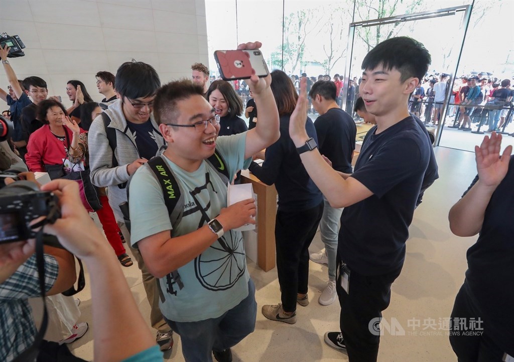 蘋果公司(Apple)在台第2家直營店「Apple信義A13」15日上午開幕,民眾難掩興奮心情,進場時與店員開心擊掌。中央社記者裴禛攝 108年6月15日
