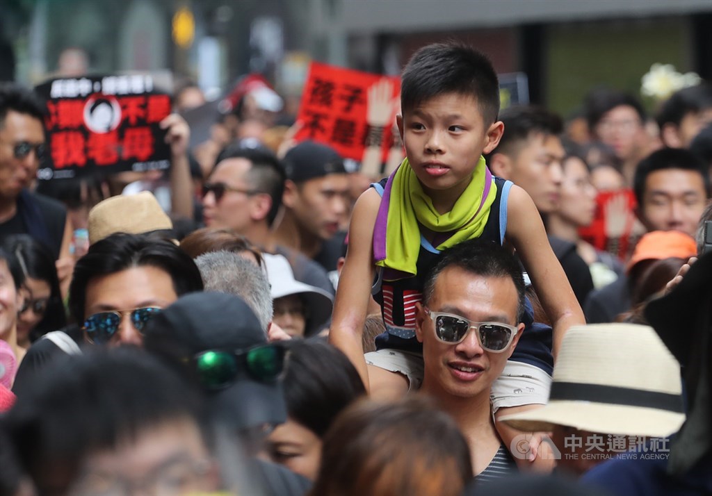 香港泛民主派團體民間人權陣線16日再次發起反修訂逃犯條例大遊行,大批民眾身穿黑衣走上街頭,有家長將孩子放在肩上跟著隊伍前進。中央社記者裴禛香港攝 108年6月16日