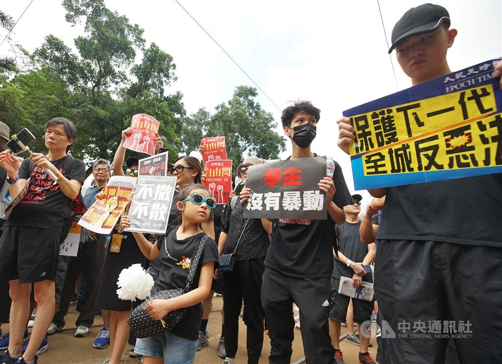 港人16日再度上街反送中,家長帶著孩子身穿黑衣走上街頭,手持標語表達訴求。中央社記者裴禛香港攝 108年6月16日