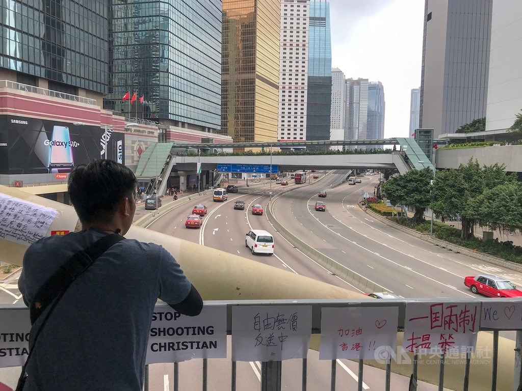 香港民陣16日號召「200萬+1」港人上街反送中遊行結束後,17日早上仍有約200人堅守夏愨道,後因擔憂港警是故意設陷阱不清場、讓遊行丟失民意;10時後已撤至立法會示威區,恢復道路通車,天橋上仍貼滿抗議標語。中央社記者裴禛香港攝 108年6月17日
