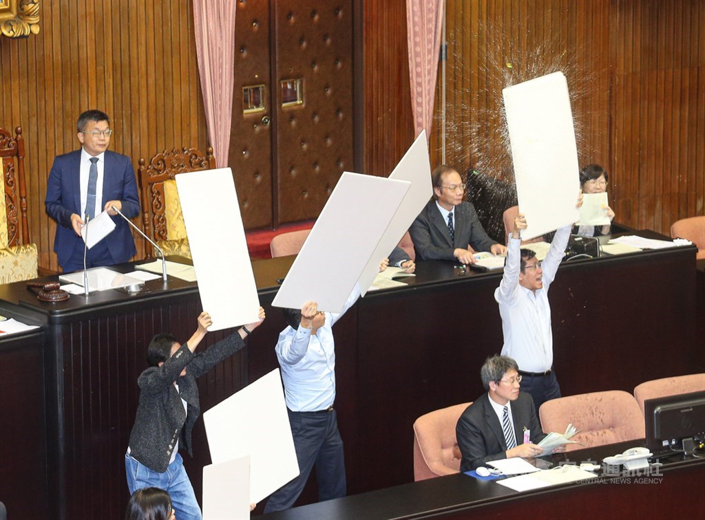 立法院會17日三讀修正通過公民投票法部分條文,在關鍵條文表決結束後,國民黨立委朝主席台丟水球,民進黨立委高舉板子阻擋。中央社記者謝佳璋攝 108年6月17日