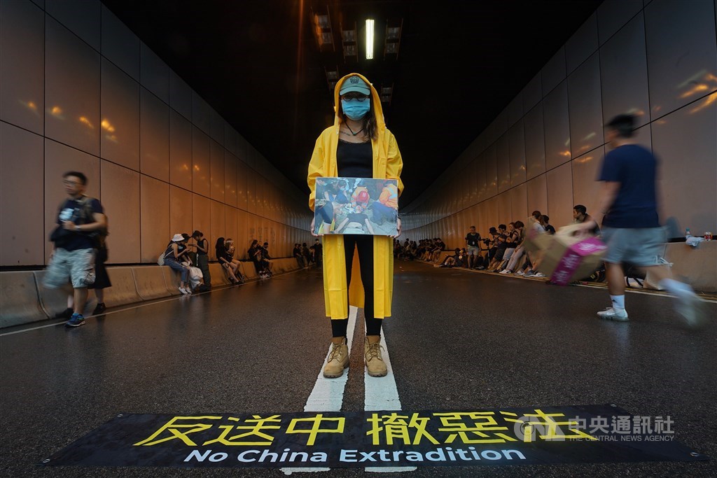 香港立法會議員17日率反修訂逃犯條例群眾至行政長官辦公室外,群眾順勢占據龍和道,一名示威者站在隧道口表訴求。中央社記者裴禛香港攝 108年6月17日