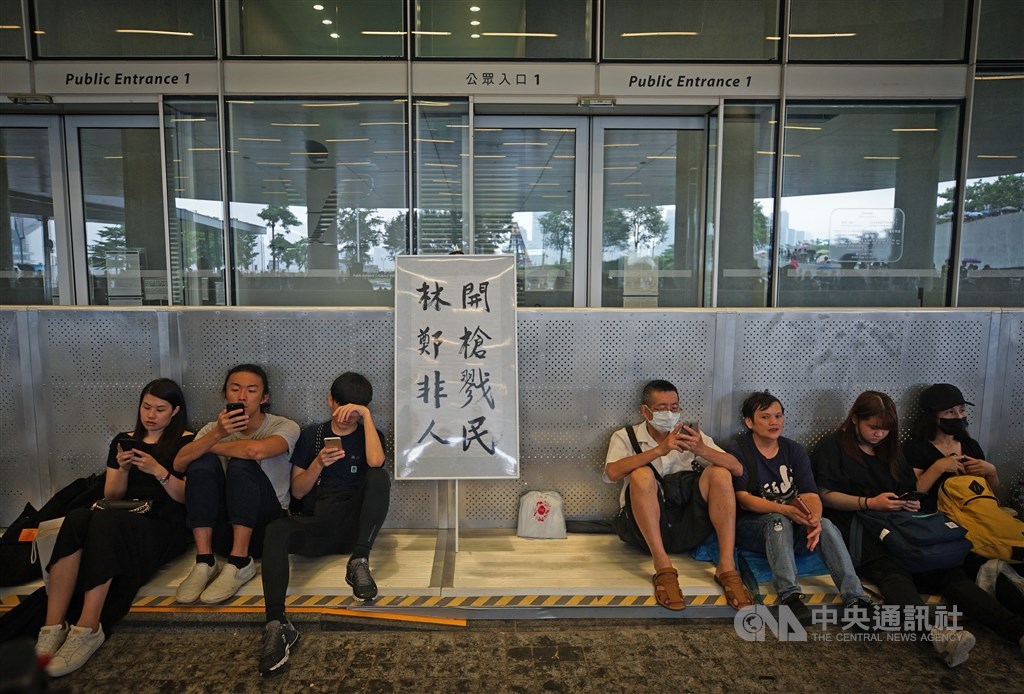 香港泛民主派團體民間人權陣線16日再度發起反修訂逃犯條例大遊行,示威者17日在立法會大樓外集結,立起抗議標語表訴求,民眾席地而坐準備長期抗爭。中央社記者裴禛香港攝 108年6月17日