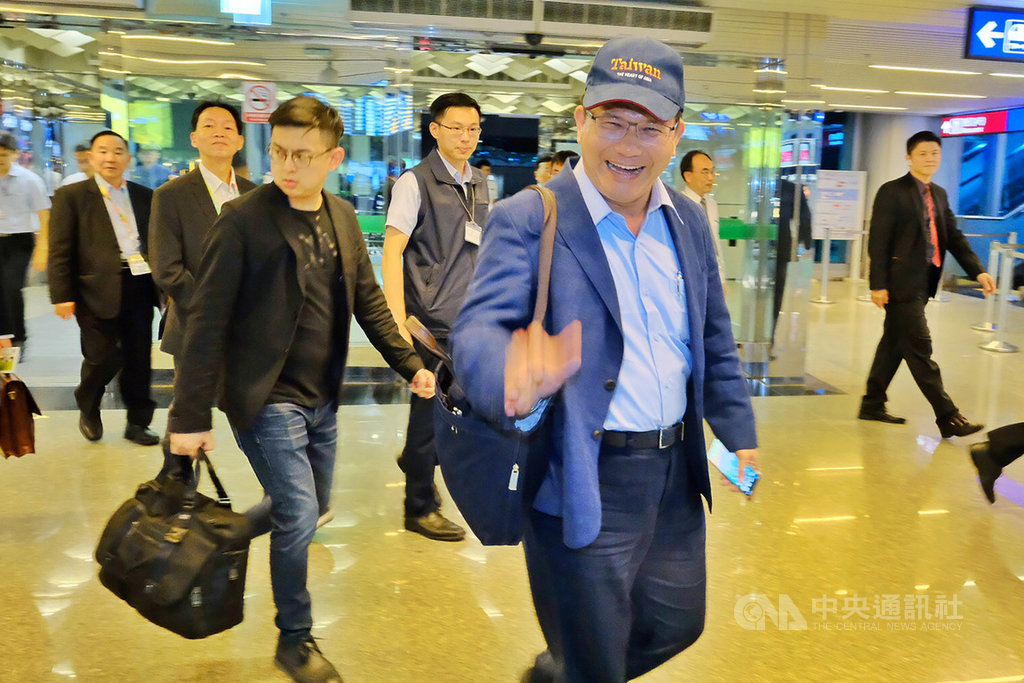 交通部長林佳龍(前右)18日晚間率團搭機出訪,將代表中華民國前往貝里斯慶祝兩國建交30週年,穿著深藍色西裝的他戴著一頂棒球帽、背著公事包相當低調。中央社記者吳睿騏桃園機場攝 108年6月18日