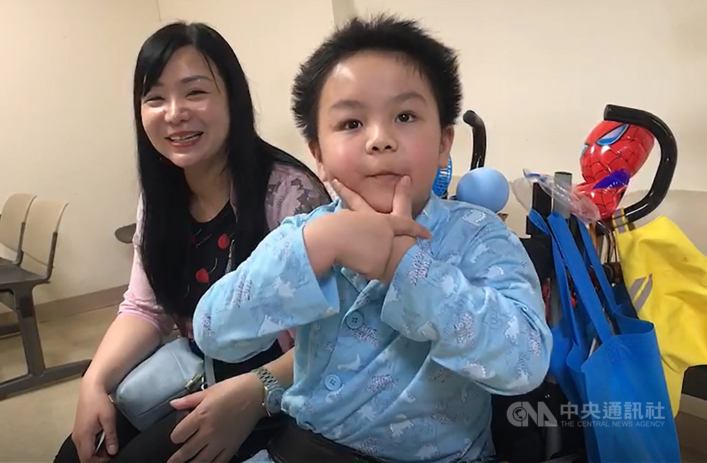 台鐵普悠瑪列車去年在宜蘭翻覆,身受重傷的7歲男童謝沛帛(右)一度昏迷,4個月後甦醒。謝沛帛母親徐美珍(左)19日帶他到醫院回診時,謝沛帛身體已好轉,還會用手勢向人打招呼,他也將在9月重返校園生活。中央社記者沈如峰宜蘭攝 108年6月19日