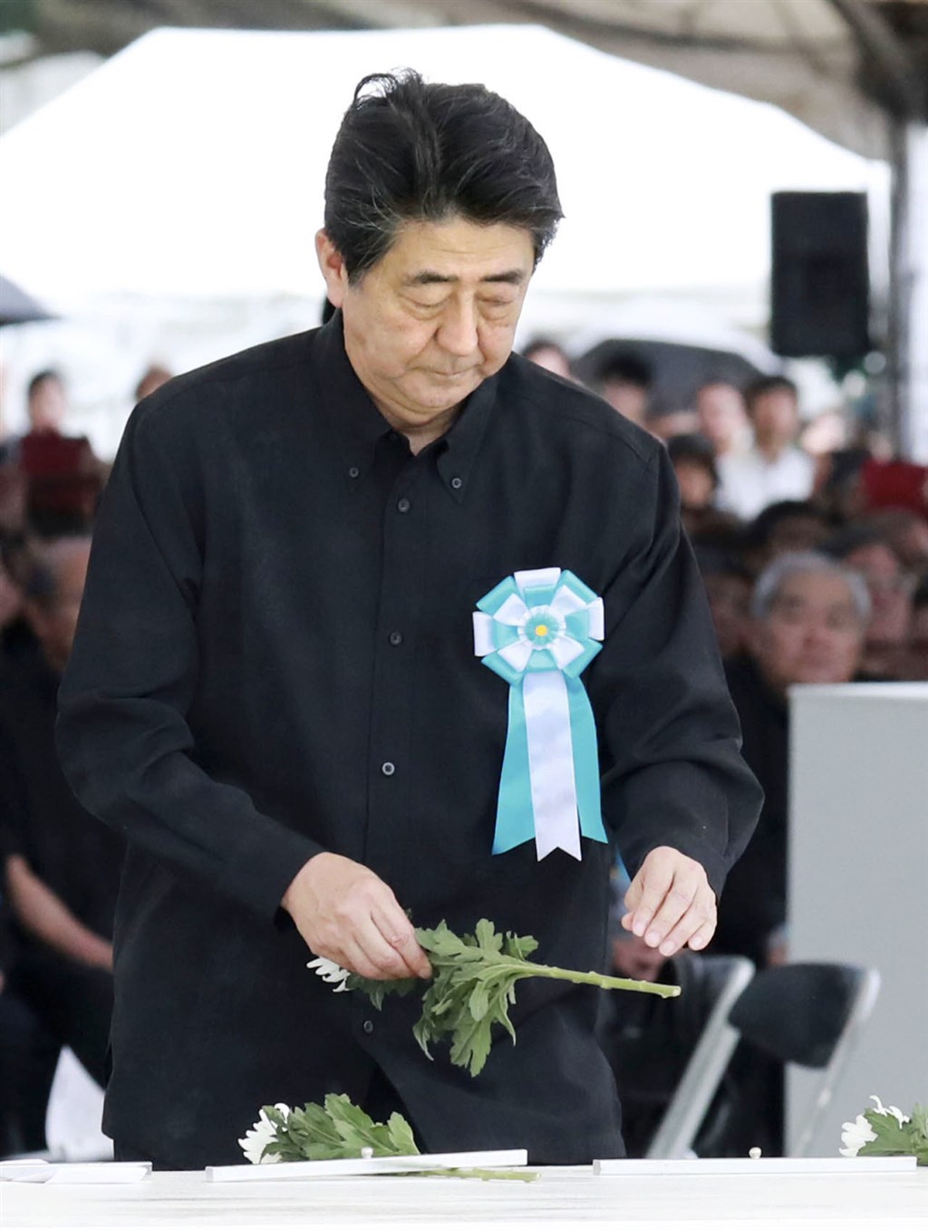日本首相安倍晉三23日參加沖繩慰靈日追悼儀式,為亡者獻花。(共同社提供)