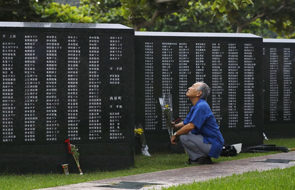 紀念日本沖繩戰役74週年,遺族們撐著傘前往「和平之礎」前獻花,將戰爭教訓傳承後代並祈求和平。(共同社提供)