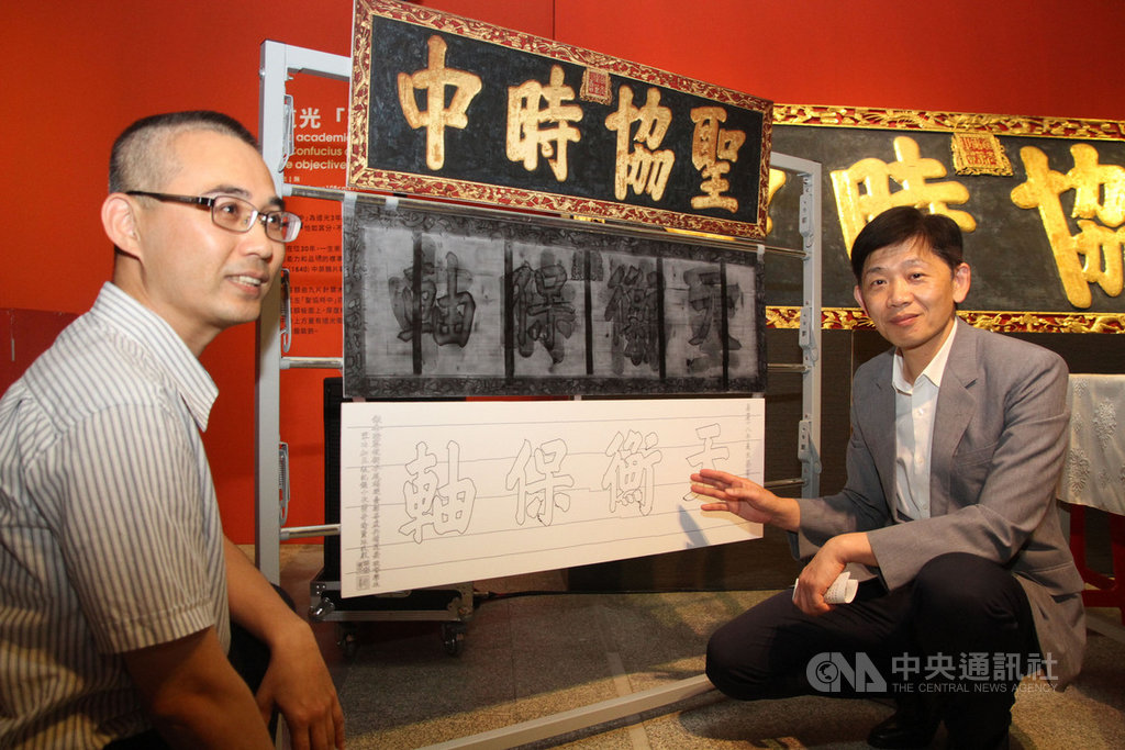 台南孔廟大成殿的清朝道光皇帝御匾「聖協時中」,近日由台南市文資處委由學者維護過程中,透過X光儀器檢測發現「聖協時中」字樣底下另有「天衡保軸」4字,研判當時是以舊匾再製。右為台南市文化局長葉澤山。中央社記者楊思瑞攝 108年6月24日