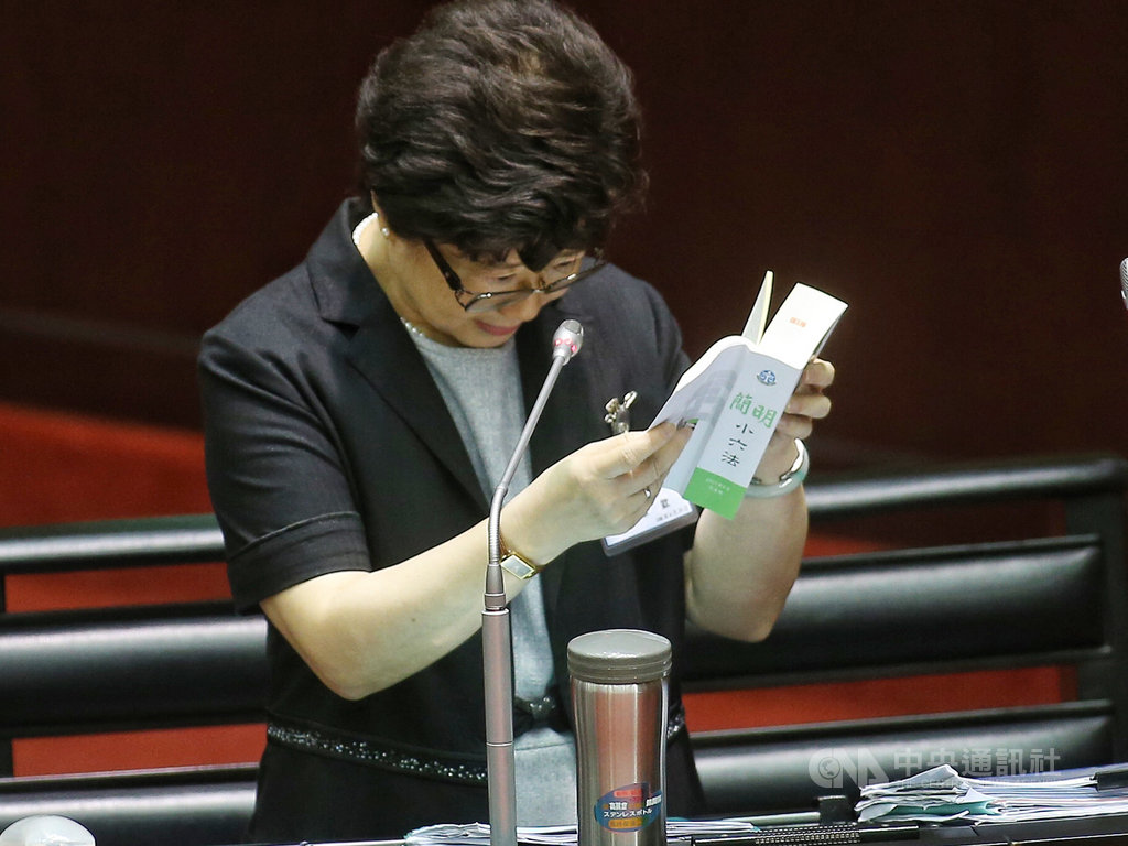 立法院25日審查大法官人事同意權案,大法官被提名人楊惠欽(圖)回答立委提問時,翻閱簡明小六法。中央社記者徐肇昌攝 108年6月25日