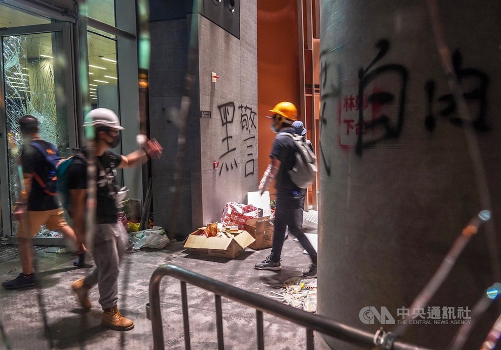 數以百計的香港示威者1日晚間撬開立法會鐵門後進一步占領議場,並將訴求寫在牆上。中央社記者裴禛香港攝 108年7月1日