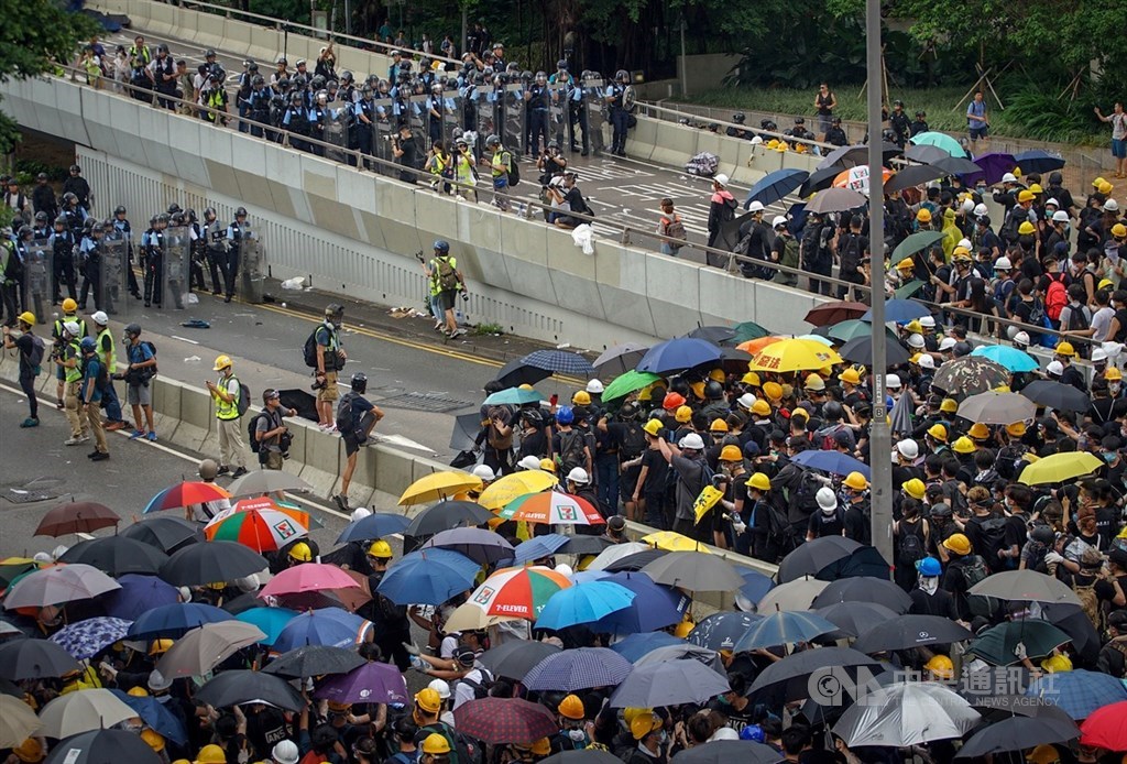 香港主權移交22週年,數百名反修訂逃犯條例的示威群眾1日擋住馬路,阻止慶祝紀念日升旗典禮,升旗結束後仍未散去,警方也還未清場。中央社記者裴禛香港攝 108年7月1日