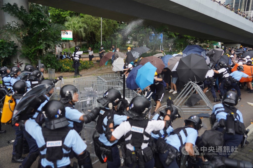 香港主權移交22週年,官方預定1日早上8時舉行升旗典禮,一群反對港府修訂逃犯條例的示威者試圖擋住馬路,阻止升旗儀式進行,與警方發生衝突。中央社記者裴禛香港攝 108年7月1日