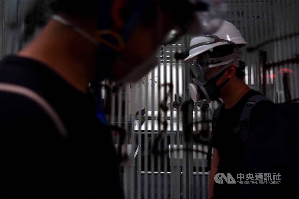示威群眾戴著安全帽、防毒面罩,全副武裝地衝進立法會,部份人士動手搗毀立法會內公物,並噴漆表達訴求。中央社記者裴禛香港攝 108年7月1日