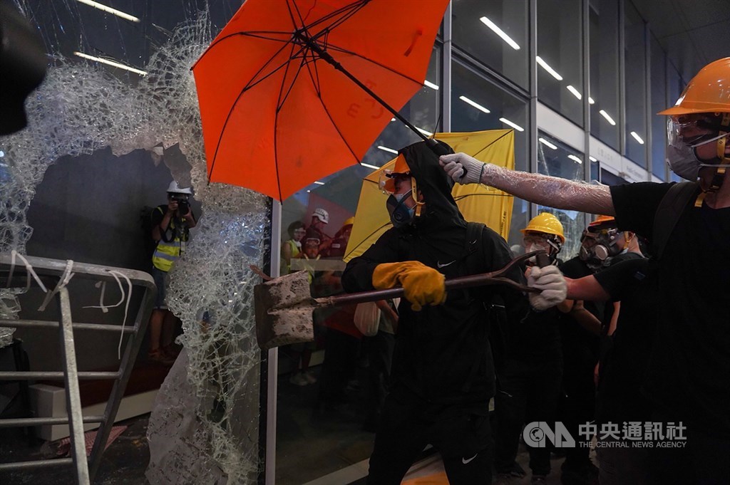 反對逃犯條例修訂的香港民眾1日持續抗爭,示威者以工具撞擊立法會玻璃大門和外牆。中央社記者裴禛香港攝 108年7月1日