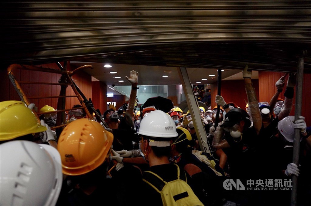 反對逃犯條例修訂的香港民眾1日持續抗爭,示威群眾晚間撬開立法會的鐵門,進一步朝立法會大樓內部前進。中央社記者裴禛香港攝 108年7月1日