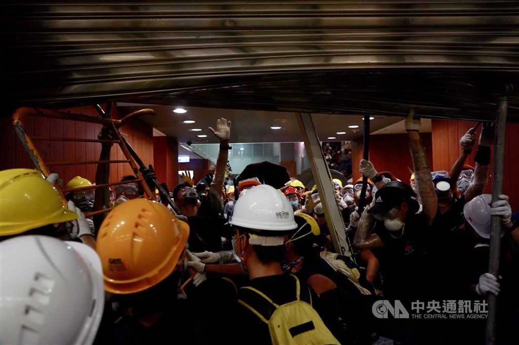 反對逃犯條例修訂的香港民眾1日持續抗爭,示威者晚間撬開立法會的鐵門後朝大樓內部前進。中央社記者裴禛香港攝 108年7月1日