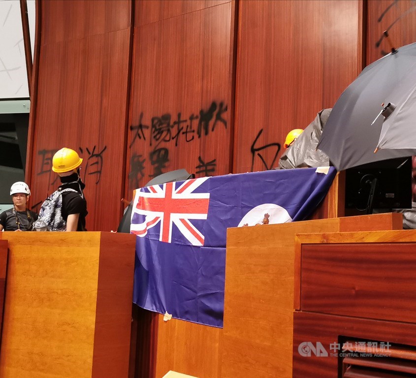 衝進香港立法會的示威者在議場內掛上英屬時代的香港旗幟。中央社記者張謙香港攝 108年7月1日