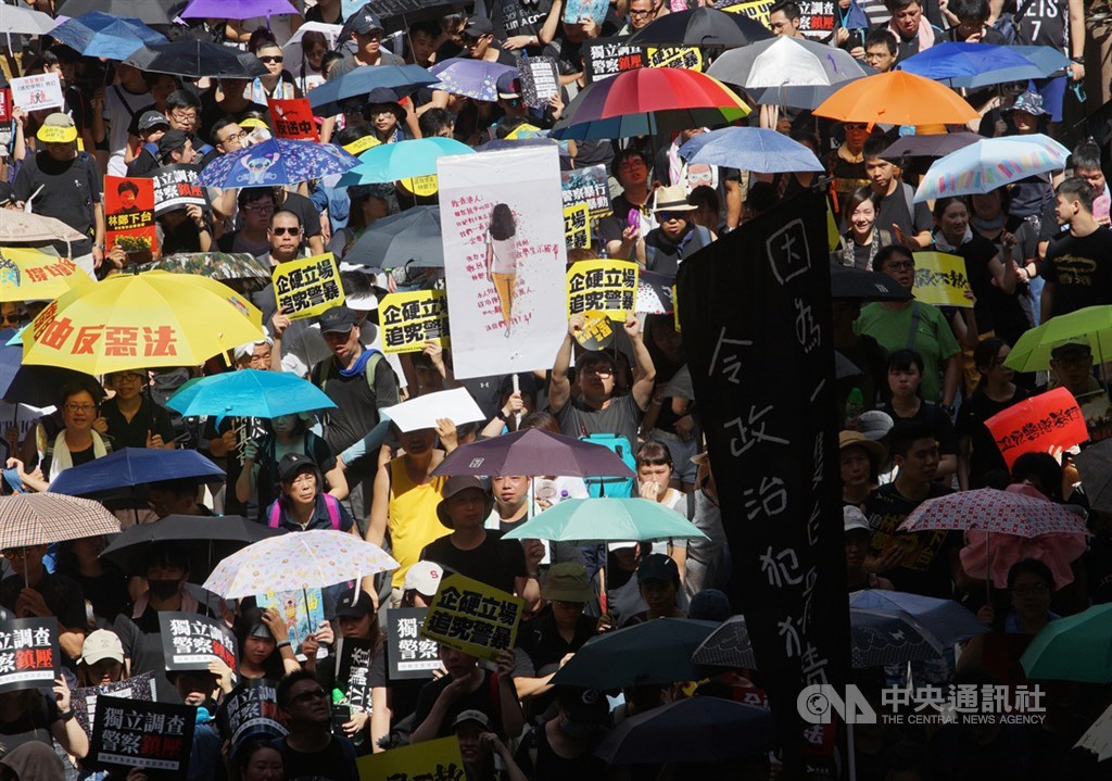 香港民眾舉牌悼念留下「反送中」字句後墜樓身亡的女學生,也有很多人在雨傘傘面寫上訴求,向世界發聲。中央社記者裴禛香港攝 108年7月1日