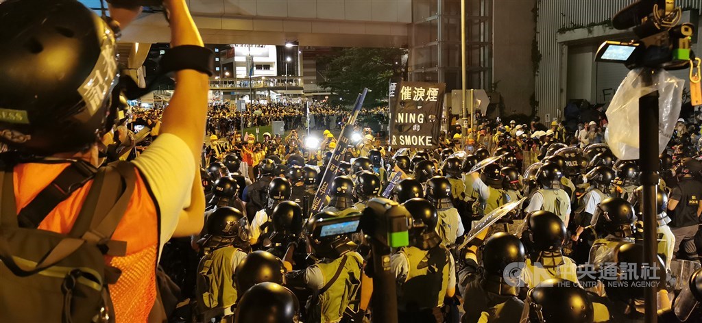 大批香港示威者1日晚間撬開立法會鐵門後進一步占領議場,港警隨即在周邊集結待命,並於2日凌晨零時陸續推進,高舉黑色催淚彈警告牌,宣示進行清場。中央社記者張謙攝 108年7月2日