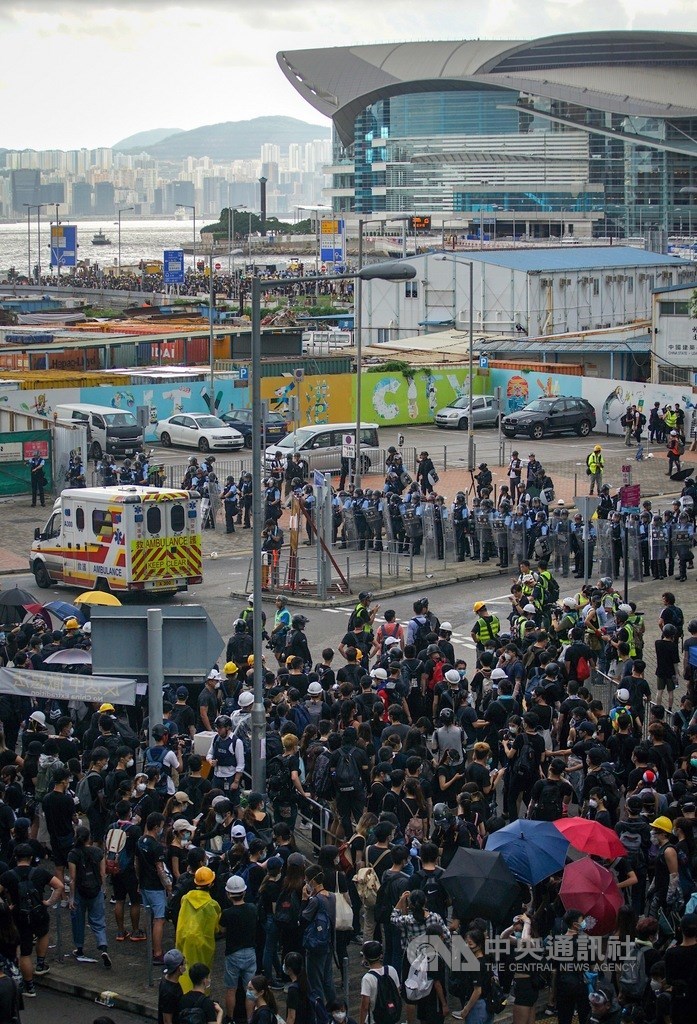香港主權移交22週年,反修訂逃犯條例的示威群眾1日為阻止慶祝紀念日升旗典禮,堵塞主要幹道,升旗結束後仍未散去,警方以人牆阻擋。中央社記者裴禛香港攝 108年7月1日