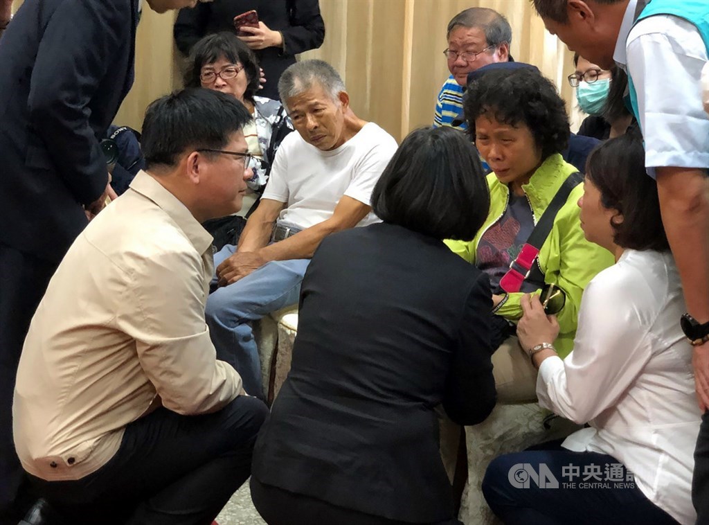 總統蔡英文(前中)4日下午在交通部長林佳龍(前左)、嘉義市長黃敏惠(右蹲者白衣)陪同下,到嘉義市立殯儀館,慰問殉職鐵路警察李承翰的父母,3人蹲下身仔細傾聽家屬心聲。中央社記者黃國芳攝 108年7月4日