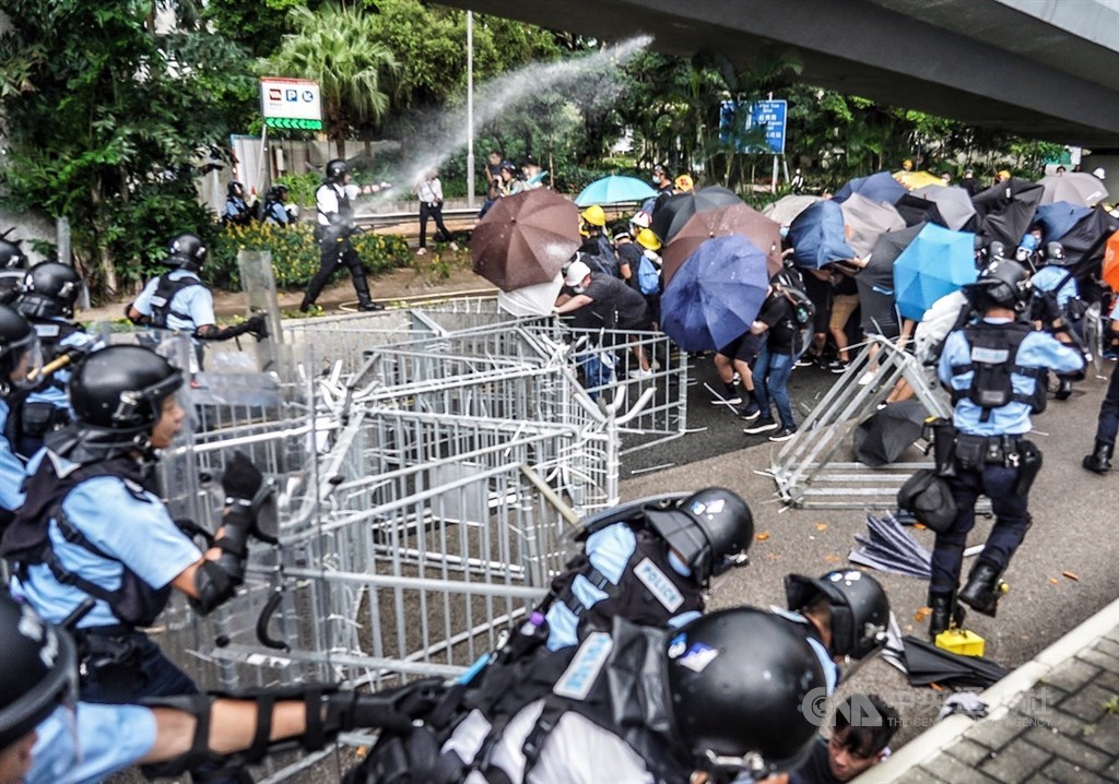 7月1日香港主權移交22週年,反對港府修訂逃犯條例的示威者當天上午試圖擋住馬路,阻擋官方舉行升旗典禮,一度與員警發生衝突,員警使用胡椒噴劑,阻止抗議群眾向前。(中央社檔案照片)