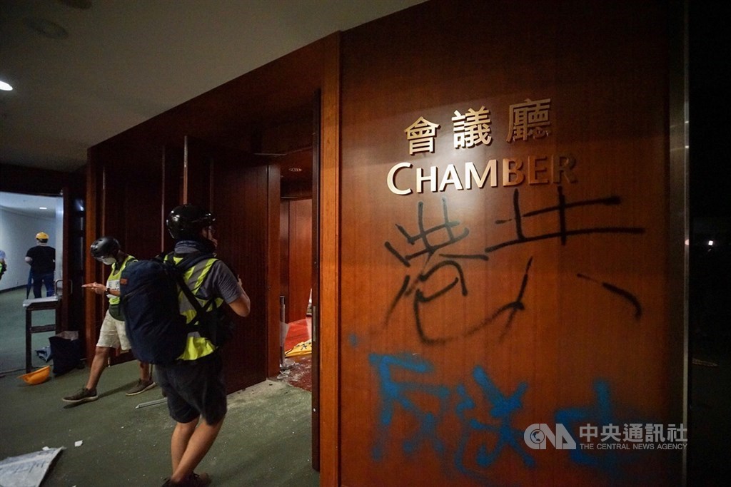 大批香港示威者1日晚間撬開立法會鐵門後占領議場,並於各處噴漆、在會議廳牆上寫下「港共」字樣等。(中央社檔案照片)