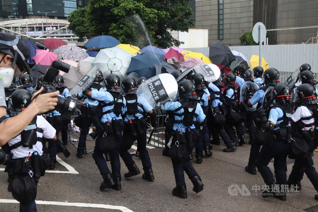 1日是香港主權移交22週年,香港警方當天上午與占據馬路、阻止升旗典禮的示威人士發生衝突。圖為警察用胡椒噴劑對付示威者。(中央社檔案照片)
