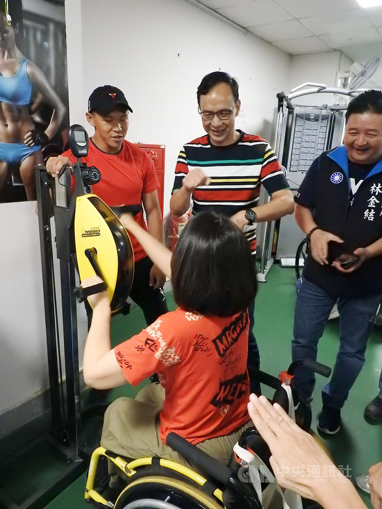 國民黨總統初選參選人朱立倫(後中)7日參訪板橋板樹體育館的「輪椅夢公園」,與身障朋友一同體驗手搖自行車等設施,了解身障朋友的運動需求。中央社記者王鴻國攝 108年7月7日