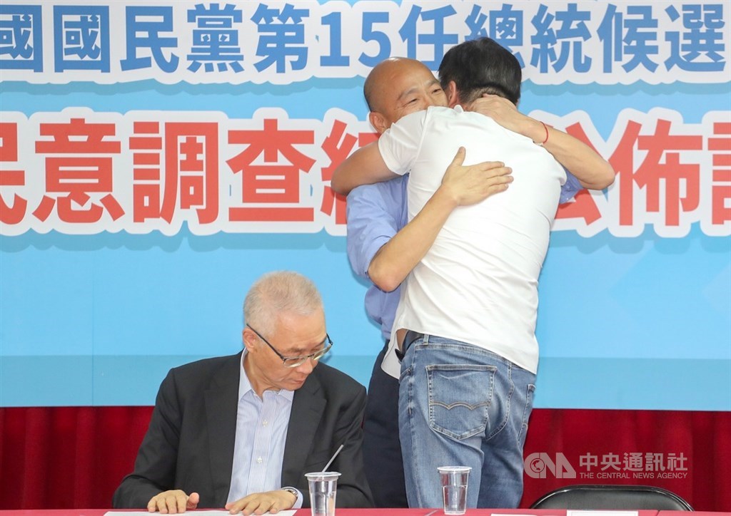 國民黨15日公布總統初選民調結果,高雄市長韓國瑜(右2)以44.805%支持度勝出,將代表國民黨角逐2020總統選戰。國民黨主席吳敦義(左)上午召開記者會,韓國瑜與前台北縣長周錫瑋(右,背對者)擁抱致意。中央社記者裴禛攝 108年7月15日