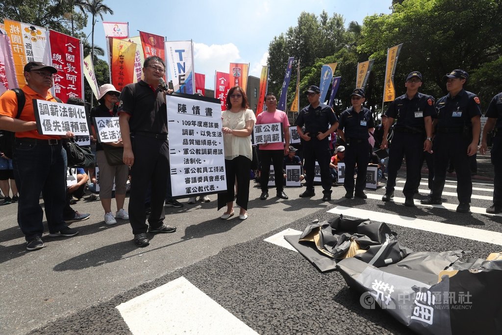 全教總「物價上漲薪水不動,要求調薪」記者會,16日在行政院大門外舉行,理事長張旭正(前左)遞交陳情書給行政院代表,盼109年度能調薪。中央社記者吳家昇攝 108年7月16日