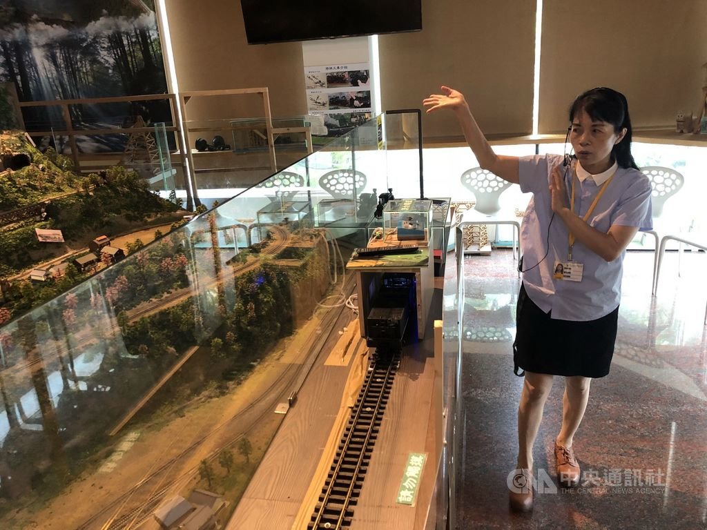 年過半百才就業的嘉義市北門森鐵故事館導覽員李淑靜,化身鐵道文化大使,透過阿里山森林鐵路模型介紹林鐵文化。(嘉義就業中心提供)中央社記者江俊亮傳真 108年7月18日