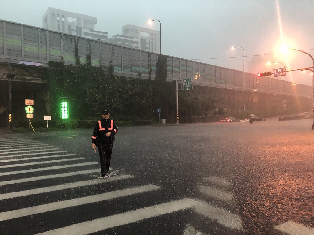 高雄市19日下午下起傾盆大雨,造成市區多處發生積淹水情形,人車受困事件頻傳,警方冒雨上街協助疏導、管制,以維護民眾安全。(民眾提供)中央社 108年7月19日