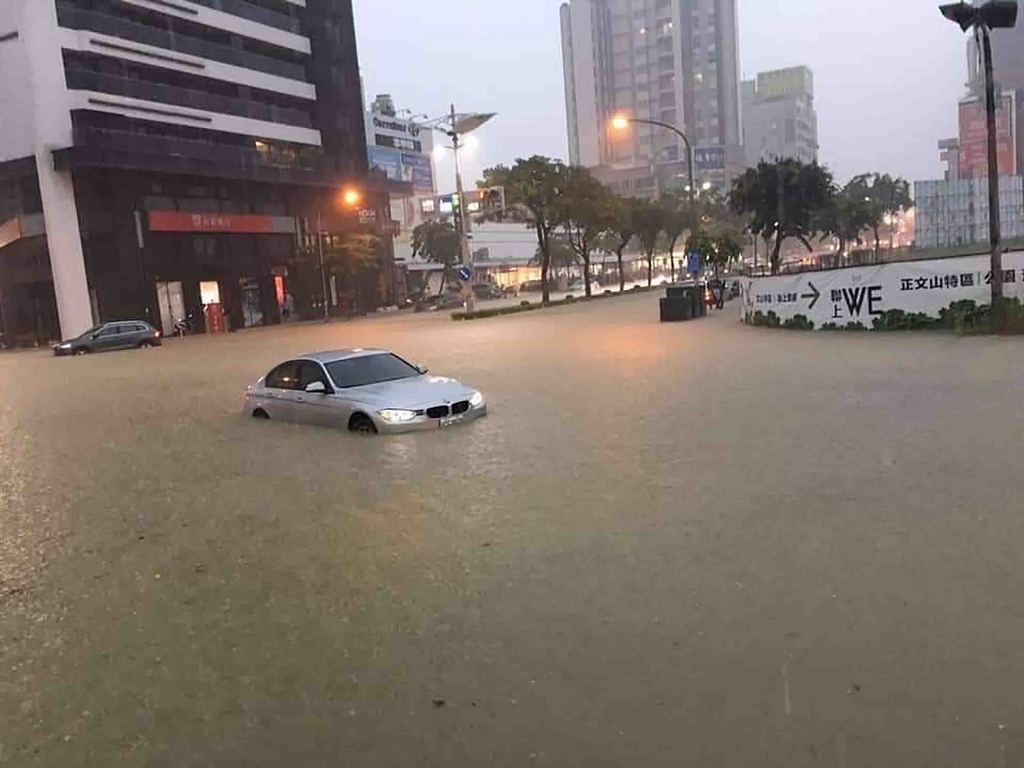 高雄市19日午後豪雨造成多處積淹水,馬路變水路,鳳山市文山特區道路積水至半個輪胎高,車輛水中慢行。(民眾提供)中央社記者董俊志傳真 108年7月19日