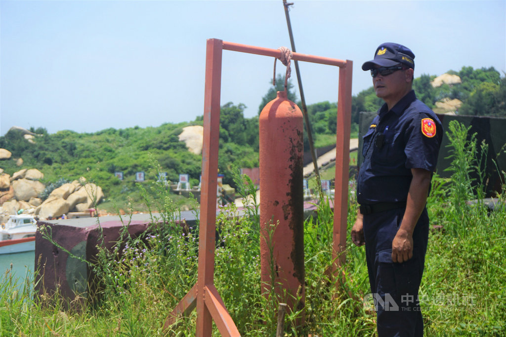 金門大膽島上駐軍每逢有船入港,就會敲鐘警示。島上派出所執勤員警潘明祥(圖)說,每天抱持觀光心情工作,樂在其中,不會「當一天和尚敲一天鐘」。中央社記者黃慧敏攝 108年7月20日