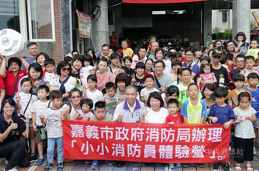 嘉義市消防局21日舉辦小小消防員體驗營,吸引逾百名小朋友化身消防員體驗救災過程,市長黃敏惠(前右5)也到場與孩童一起體驗。中央社記者黃國芳攝 108年7月21日