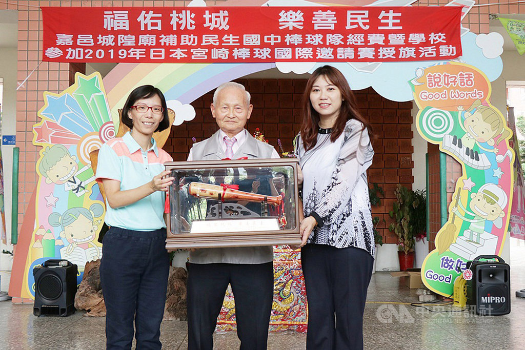 嘉義市民生國中棒球隊8月將赴日比賽,嘉義城隍廟董事長賴永川(中)代表廟方贊助新台幣20萬元,做為棒球隊一年的訓練經費,校長陳明君(左)回贈球棒造型紀念品。(嘉義市政府提供)中央社記者江俊亮傳真 108年7月22日
