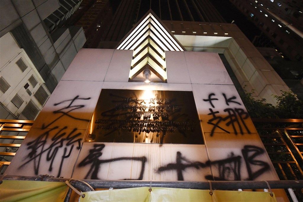 香港21日反送中遊行結束後,部分示威者圍堵中聯辦,並在外牆噴上侮辱字句。(共同社提供)