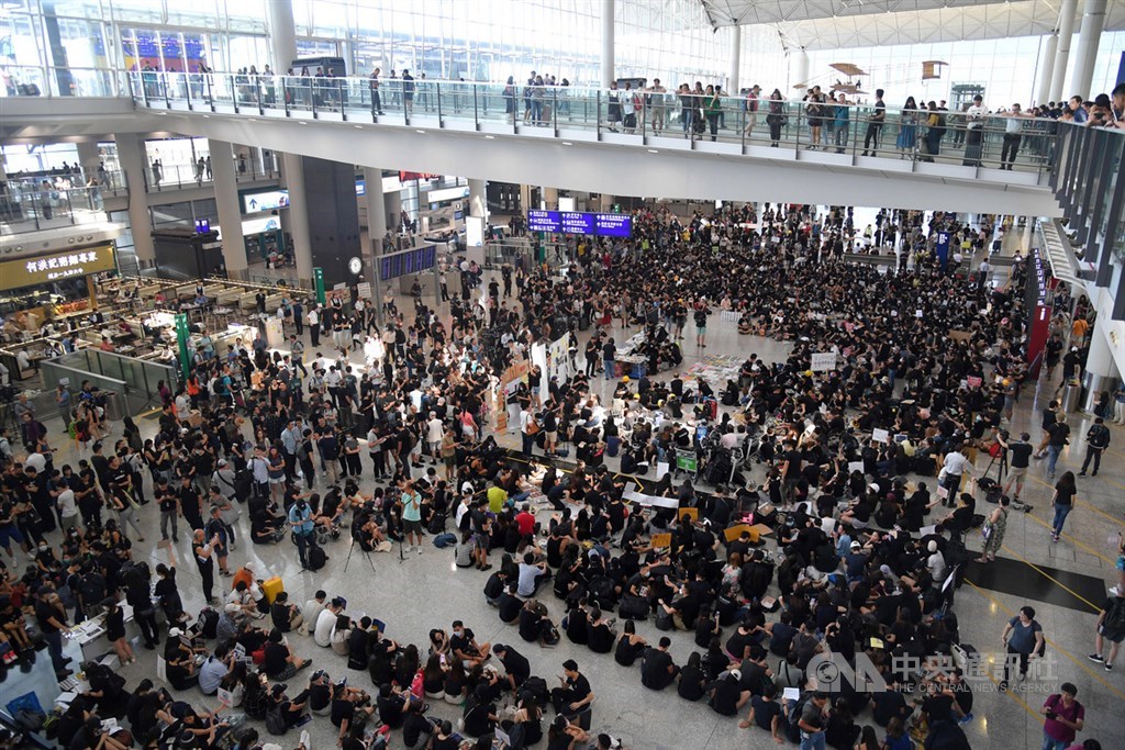 香港航空界從業員26日在在香港機場入境大廳發起集會,要求政府撤回修訂逃犯條例,並調查警方在驅散「反送中」示威者時有否濫用權力,他們身穿黑衣,在機場接機大廳劃定示威區內靜坐。中央社記者王飛華攝 108年7月26日