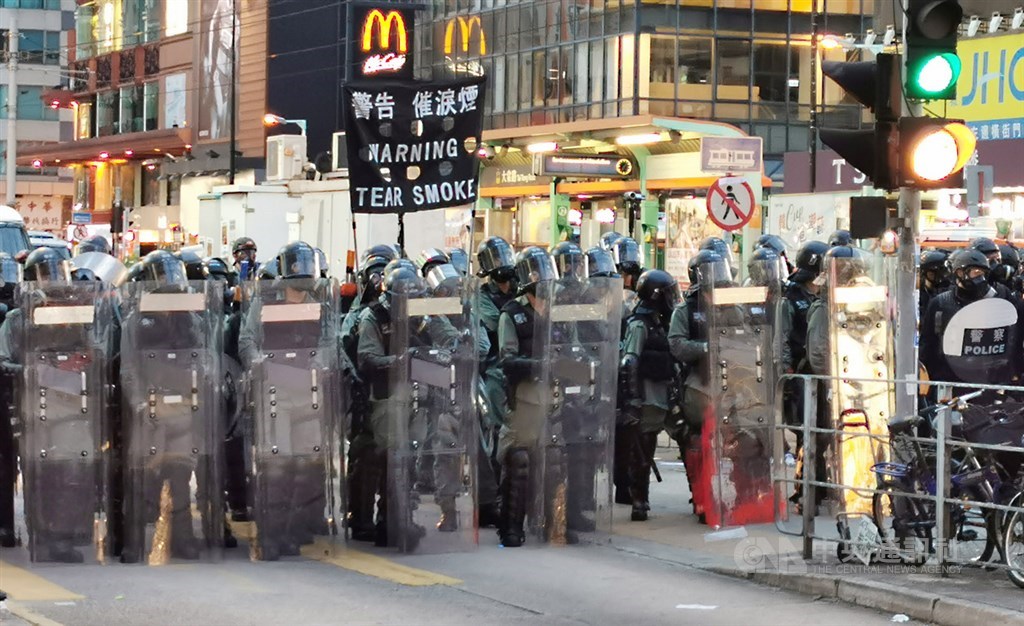 香港「反送中」未歇,27日「光復元朗」遊行再度聚集大批群眾,晚間7時,防暴警察高舉黑旗,警告示威者將施放催淚彈。 中央社記者張謙攝 108年7月27日