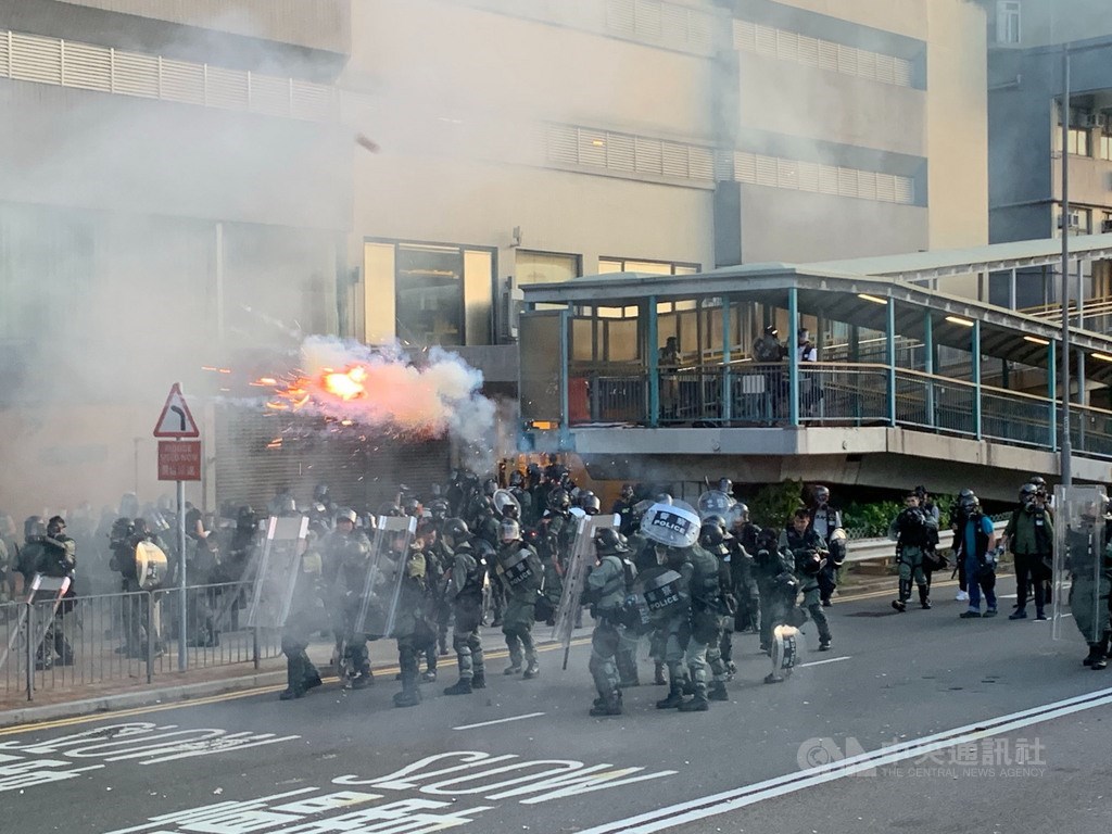 香港反送中自主遊行的部分示威人士,28日下午包圍中聯辦,港警派出大批防暴警察鎮守,並在晚間7時高舉黑旗、隨即施放催淚彈進行清場。中央社記者廖漢原香港攝 108年7月28日