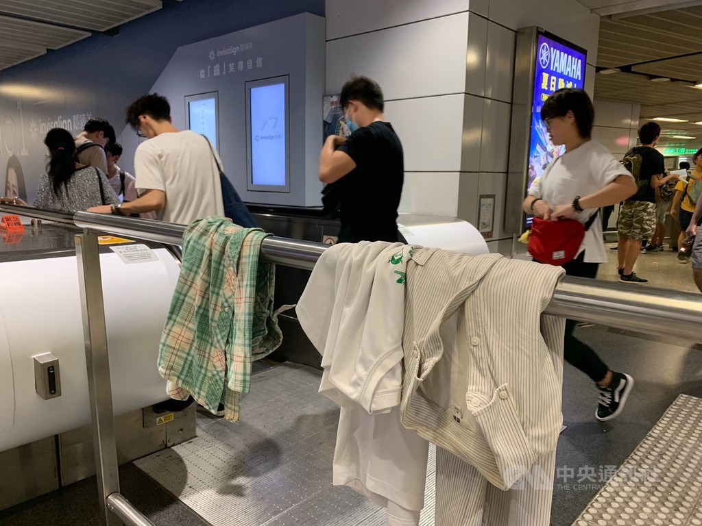 香港反送中運動持續延燒,28日在中環集會活動至晚間擴大至上環、西環一帶,警方也出動強勢清場,由於擔心日前黑衣示威者遭暴力襲擊事件重演,在地鐵中環站內有各式衣物披掛在欄杆上,供有需要者自由取用。中央社記者廖漢原香港攝 108年7月28日