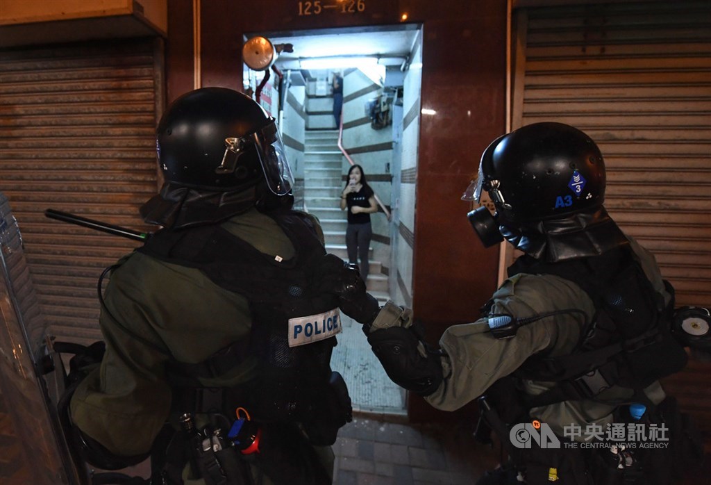 香港反送中示威者28日傍晚再度聚集在中聯辦大樓前抗議,鎮暴警察晚間開始驅離示威群眾並逐門清查。中央社記者王飛華攝 108年7月28日