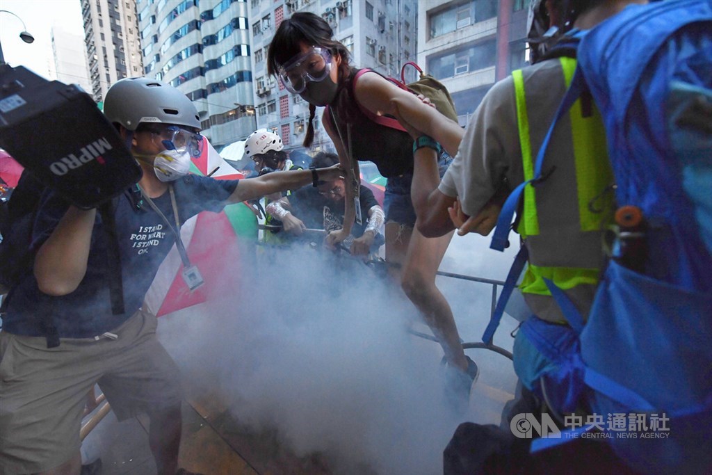 香港28日中環遮打花園追究警方用槍集會,演變成大規模「非法」遊行,香港警方晚間7時高舉黑旗、隨後發射催淚彈意圖驅離,抗議群眾往周邊區域移動。中央社記者王飛華香港攝 108年7月28日