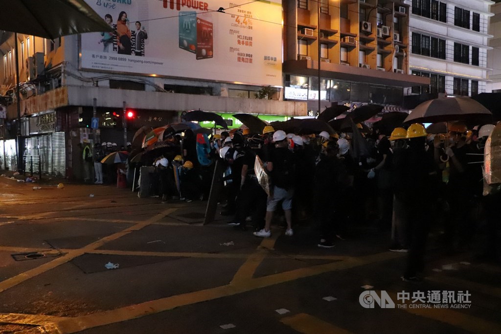 香港中環遮打花園追究警方用槍集會,演變為西環包圍中聯辦;港警晚間7時起清場,沿途狂射催淚彈意圖逼退示威者,有記者、示威者頭破血流,多人遭逮捕。圖為警方與示威者在上環一帶對峙。中央社記者張謙香港攝 108年7月28日