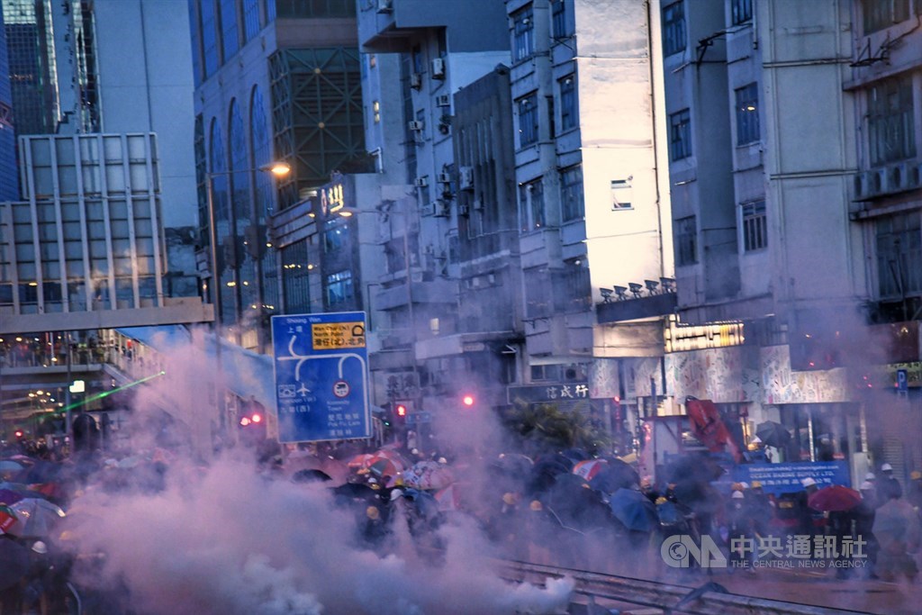 香港中環遮打花園28日舉行的追究警方濫權集會,演變為大規模「自主」遊行,香港警方晚間開始大規模使用催淚彈驅離,部分示威者以雨傘防護。中央社記者王飛華香港攝 108年7月28日