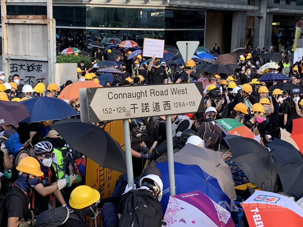 反送中示威者27日在西環與警方爆發衝突,示威者將道路指示牌「干諾道西」拔起。中央社記者廖漢原香港攝 108年7月29日