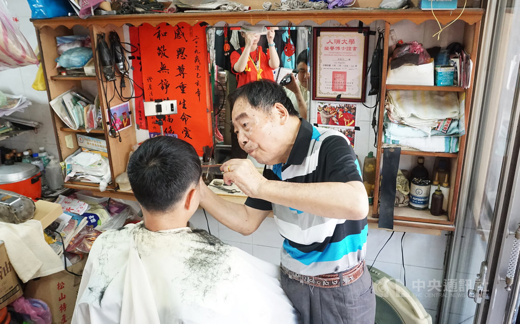 華山基金會30日在台北舉行「華山人瑞理髮好手藝 歡度過父親節」記者會,從事理髮超過70年的人瑞理髮師林能火(右)現場展示理髮手藝。中央社實習記者房荷庭攝 108年7月30日