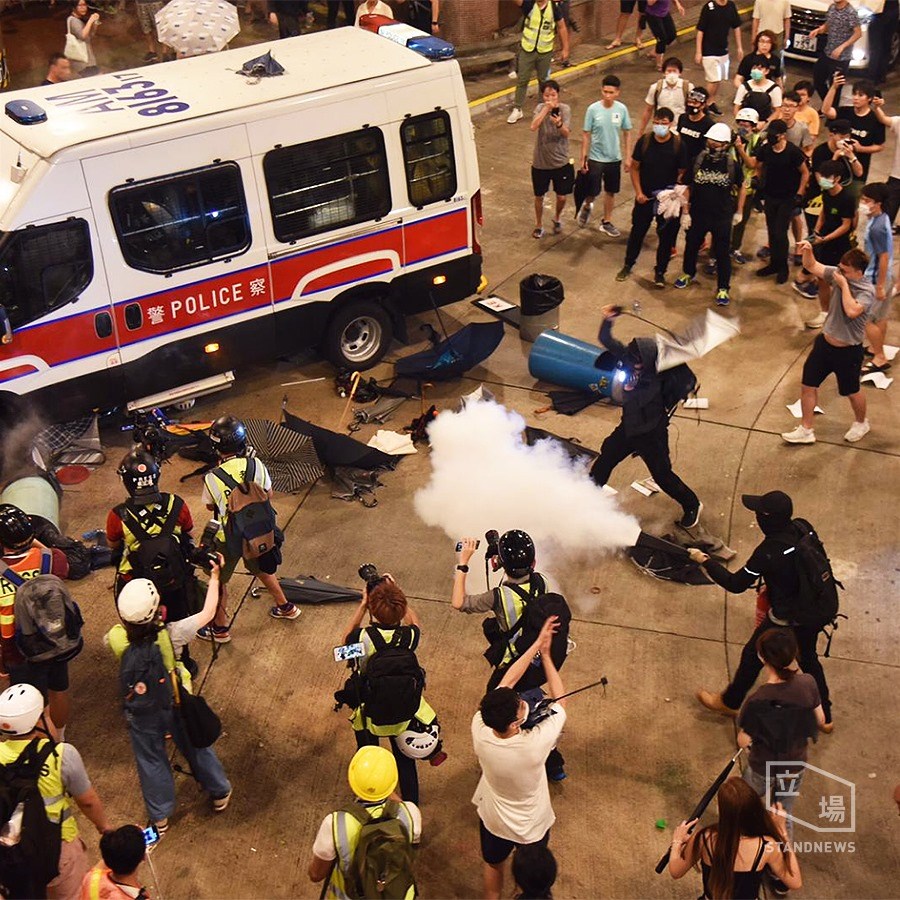 晚間約11時52分,數名警察走下在黃大仙巴士總站被圍的警車,揮舞警棍並噴灑胡椒噴霧試圖開路,現場民眾也以滅火器反制。(圖取自facebook.com/standnewshk)